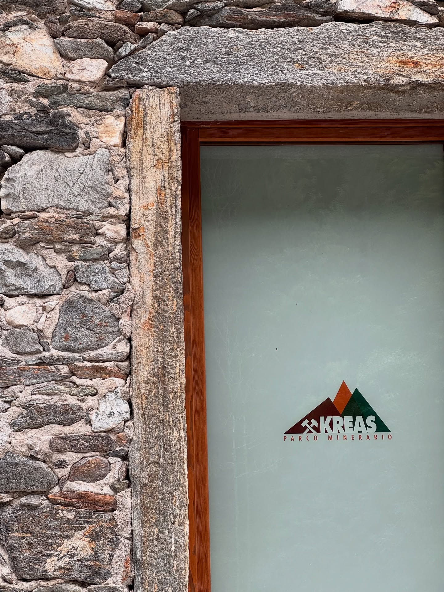Logo Kreas Parco Minerario sulla porta in pietra